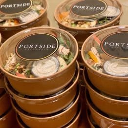 Stacked Portside Catering containers with branded lids