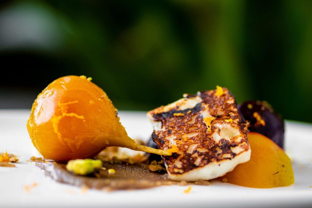Plated course with cured egg yolk, seared halloumi and squash purée