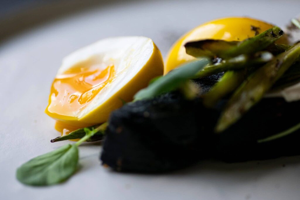Soft egg with charred asparagus and a squid ink bun