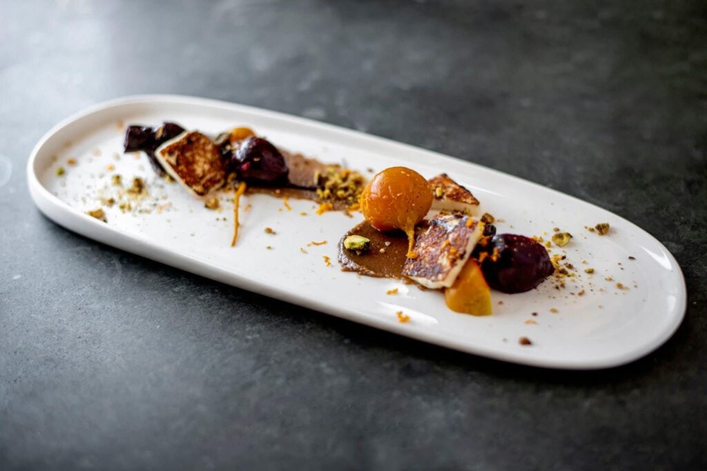 Long white plate with roasted beets, apricot and pistachio