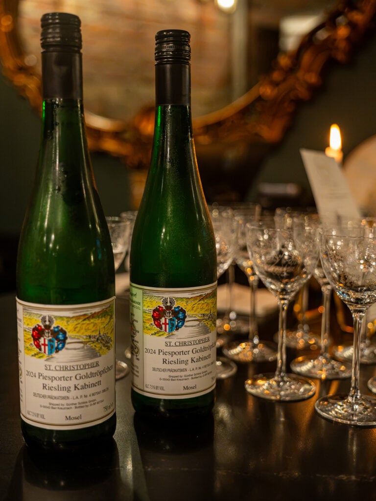 Two bottles of Riesling beside wine glasses set out for service